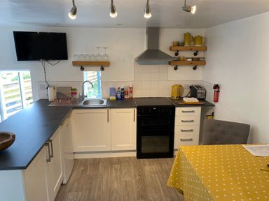 A kitchen with appliances and a dining area at The Haven in Penrith