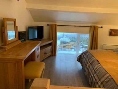 A bedroom with a bed, dresser, and television at The Haven in Penrith