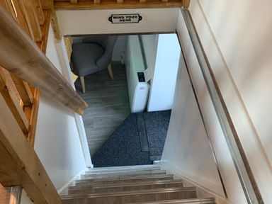 A staircase leading to a doorway with a sign at The Haven in Penrith