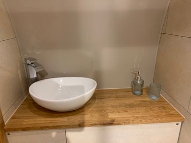 A wash basin and faucet on a wooden countertop at Cosy Escape in Sheerness
