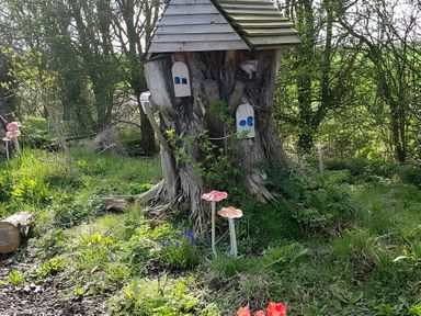 A tree house built on a tree stump in a garden at Cosy Escape in Sheerness