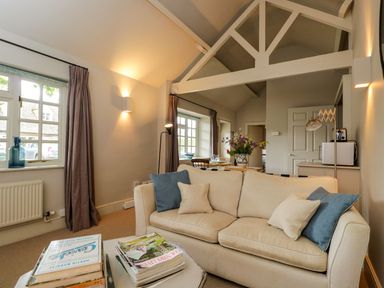 A living room with a sofa and a dining table at Foxhill Farm Barn in Cheltenham
