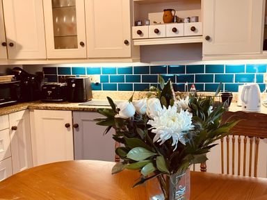 A kitchen with a vase of flowers on a table at Fountain Hill House Londonderry