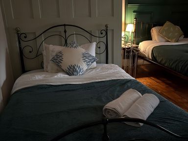 A bedroom with two beds and towels on the first bed at Fountain Hill House Londonderry