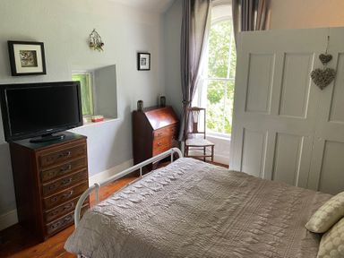 A bedroom with a bed and television at Fountain Hill House Londonderry
