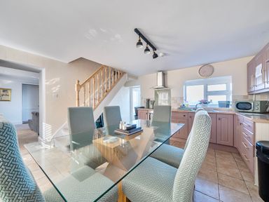 A dining room with a glass table and chairs at Sea view cottage in Penmaenmawr