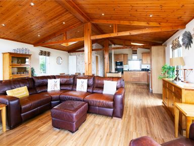 A living room with a sofa and dining area at Hedgehog Lodge in York