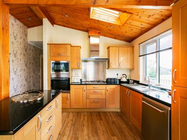 A kitchen with wood cabinets and appliances at Hedgehog Lodge in York