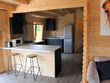 A kitchen with a sink, refrigerator, and stools at Cotswold Nights Away in Evesham