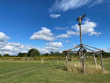 A wooden sculpture structure in a grassy area at Cotswold Nights Away Evesham