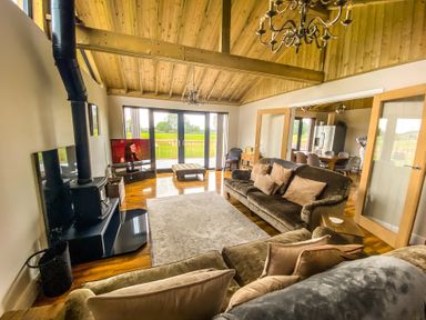 A living room with a sofa and television at Fox Lodge in York