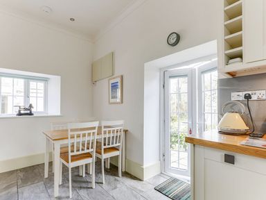 A kitchen with a table and chairs at Poppyfields Stable in Redruth