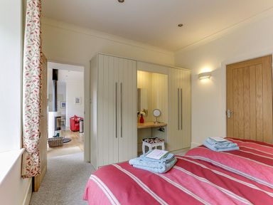 A bedroom with two beds and a wardrobe at Poppyfields Stable Redruth