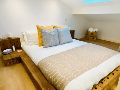 A bedroom with a bed and nightstands at Honey Bee Cottage in Welshpool