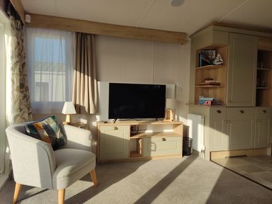 A living room with a television and armchair at Harbour View in Poole