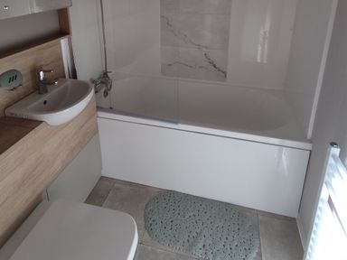 A bathroom with a bathtub, sink, and toilet at Harbour View in Poole