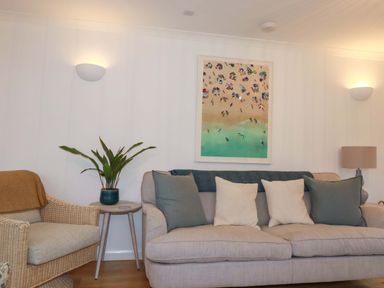 A living room with a sofa and artwork at Poldreth in Truro