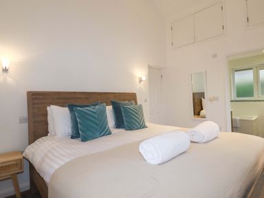 A bedroom with a bed and bathroom access at Poldreth in Truro