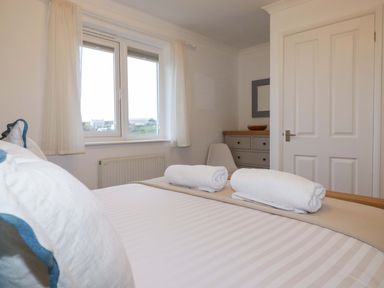 A bedroom with a bed and towels on top at Poldreth in Truro