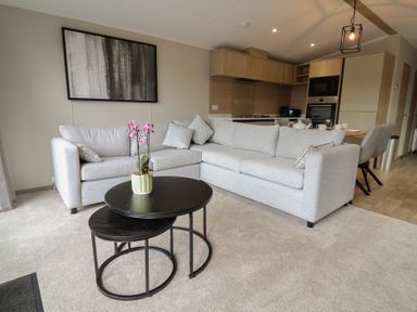A living room with a sofa and coffee table at The Pines 3 Bedrooms in Delamere