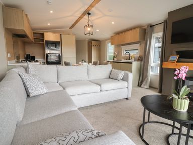A living room with a sofa and coffee table at The Pines 3 Bedrooms in Delamere
