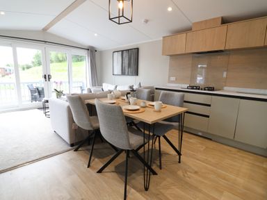 A dining area with a table and chairs at The Pines 3 Bedrooms in Delamere