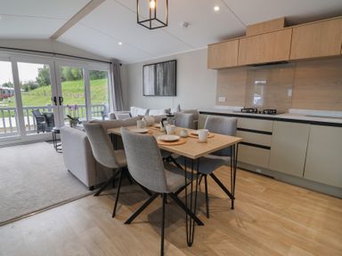 A dining room with a table and chairs at The Pines 3 Bedrooms Delamere