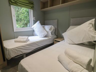 A bedroom with two beds and a window at The Pines 3 Bedrooms Delamere