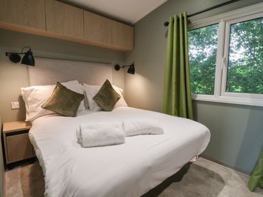 A bedroom with a bed and bedside table at The Pines 3 Bedrooms Delamere