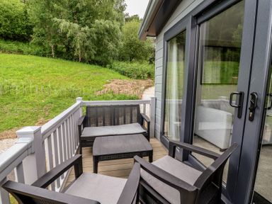 A terrace with chairs and a table at The Pines 3 Bedrooms Delamere