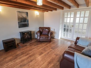 A living room with a fire place and two sofas at Rhosgranog Cottage Llandeloy near Solva