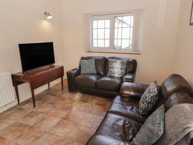A living room with a sofa and television at Rhosgranog Cottage Llandeloy near Solva