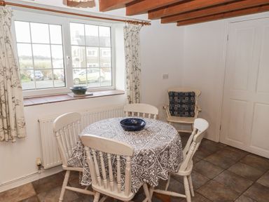 A dining room with a table and chairs at Rhosgranog Cottage in Llandeloy near Solva