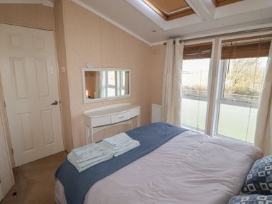 A bedroom with a bed and a mirror at Rhosgranog Caravan in Llandeloy near Solva