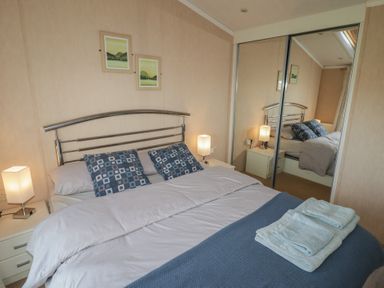 A bedroom with a bed and lamps at Rhosgranog Caravan Llandeloy near Solva