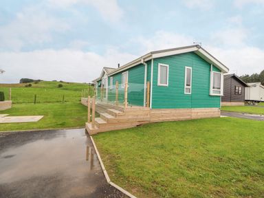A mobile home with decking and steps at No 8 Hillcote Lodge in Cockermouth