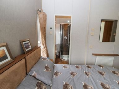 A bedroom with a bed and shower in No 8 Hillcote Lodge Cockermouth