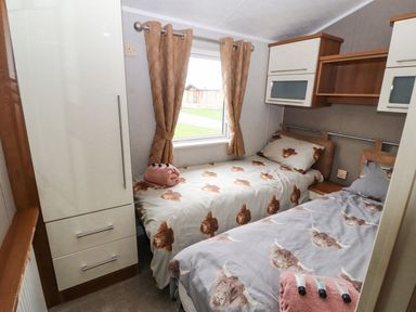 A bedroom with two beds and a wardrobe at No 8 Hillcote Lodge in Cockermouth