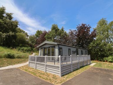 A house with decking and windows at The Oaks 2 Bedrooms in Delamere