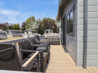 An outdoor area with chairs and deck at The Oaks 2 Bedrooms Delamere