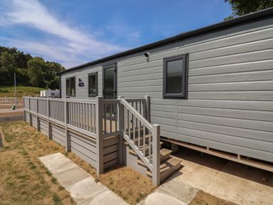 A mobile home with a staircase and decking at The Oaks 2 Bedrooms in Delamere