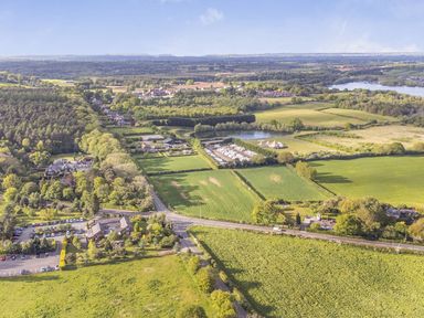 An aerial view of fields, trees, and houses at The Oaks 2 Bedrooms in Delamere