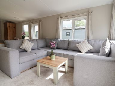 A living room with a sofa and coffee table at The Oaks 2 Bedrooms Delamere