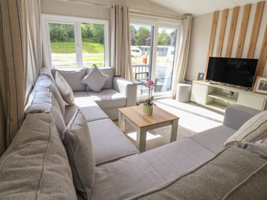 A living room with a sofa and coffee table at The Oaks 2 Bedrooms Delamere
