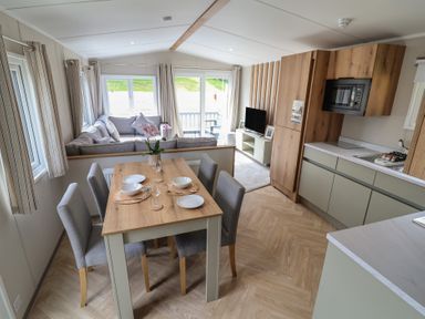 A dining area and living space with sofa and kitchen at The Oaks 2 Bedrooms Delamere