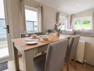 A dining room with a table and chairs at The Oaks 2 Bedrooms in Delamere