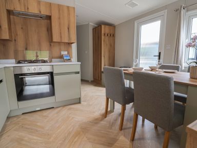 A kitchen with an oven and dining area at The Oaks 2 Bedrooms Delamere