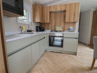A kitchen with cabinets and appliances at The Oaks 2 Bedrooms Delamere