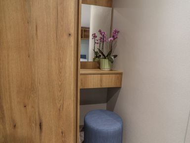 A dressing area with a mirror and flower pot at The Oaks 2 Bedrooms in Delamere