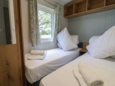 A bedroom with two beds and a window at The Oaks 2 Bedrooms in Delamere